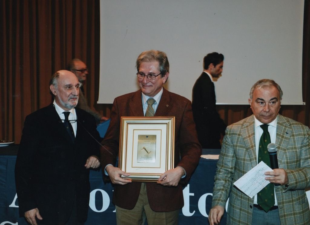 Massimo Serra (al centro) in rappresentanza della Scuderia Marche fra il presidente dell’ASI Roberto Loi (a sinistra) e Pietro Piacquadio presidente commissione manifestazioni dell’ASI, mostra orgoglioso l’ottava Manovella d’Oro assegnata al suo club in appena dieci anni di vita