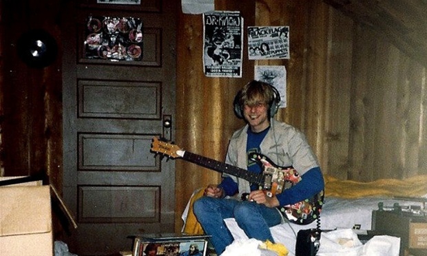 In this undated photo provided by Kim Cobain, a young Kurt Cobain plays guitar in his childhood home in Aberdeen, Wash. Cobain's mother, Wendy O'Connor, is putting the 1.5-story Aberdeen bungalow _ which is assessed at less than $67,000 _ on the market for $500,000. But she'd also be happy entering into a partnership with anyone who wants to turn it into a museum. (AP Photo/Courtesy Kim Cobain)