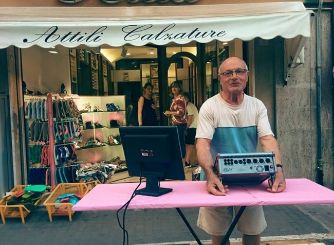 Stelvio Attili, attaccante della Triestina anni 50-60, allestisce un mini-palco davanti al suo negozio di calzature