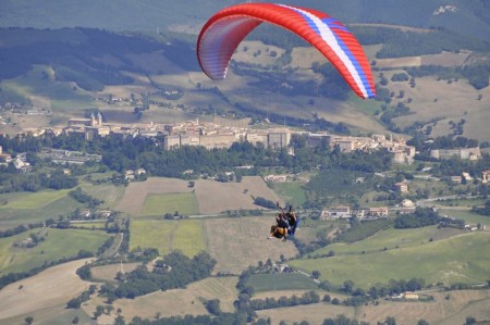 Parapendio biposto in volo da Montelago con la citta di Camerino sullo sfondo
