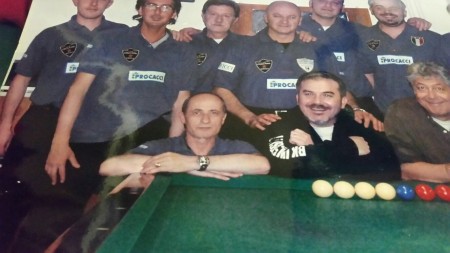 Gianni Rossi con la squadra di boccette in una foto che campeggia su un muro del circolo di via Severini