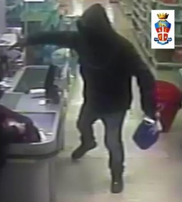 Il rapinatore vicino alla cassa