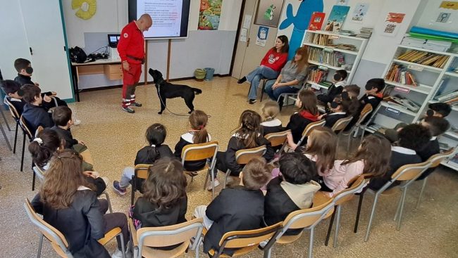 Loperatore-Andrea-Antonini-mostra-come-si-impartiscono-comandi-a-Indro-il-cane-della-Croce-Rossa-Italiana